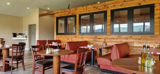 Wood-paneled dining room with red booths at Mama Mia Pie and Pasta