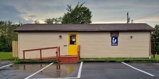Mountaintop Public Library exterior with its yellow entrance door and library sign