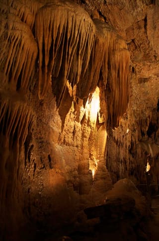 Golden stalactites and rock formations inside Smoke Hole Caverns
