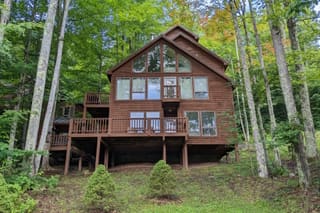 View of the entire back of Trail Magic Chalet from the backyard in summer