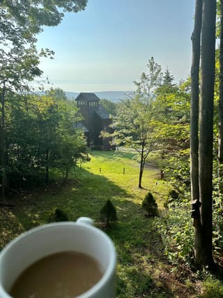 Morning coffee overlooking the wooded hillside and distant mountains